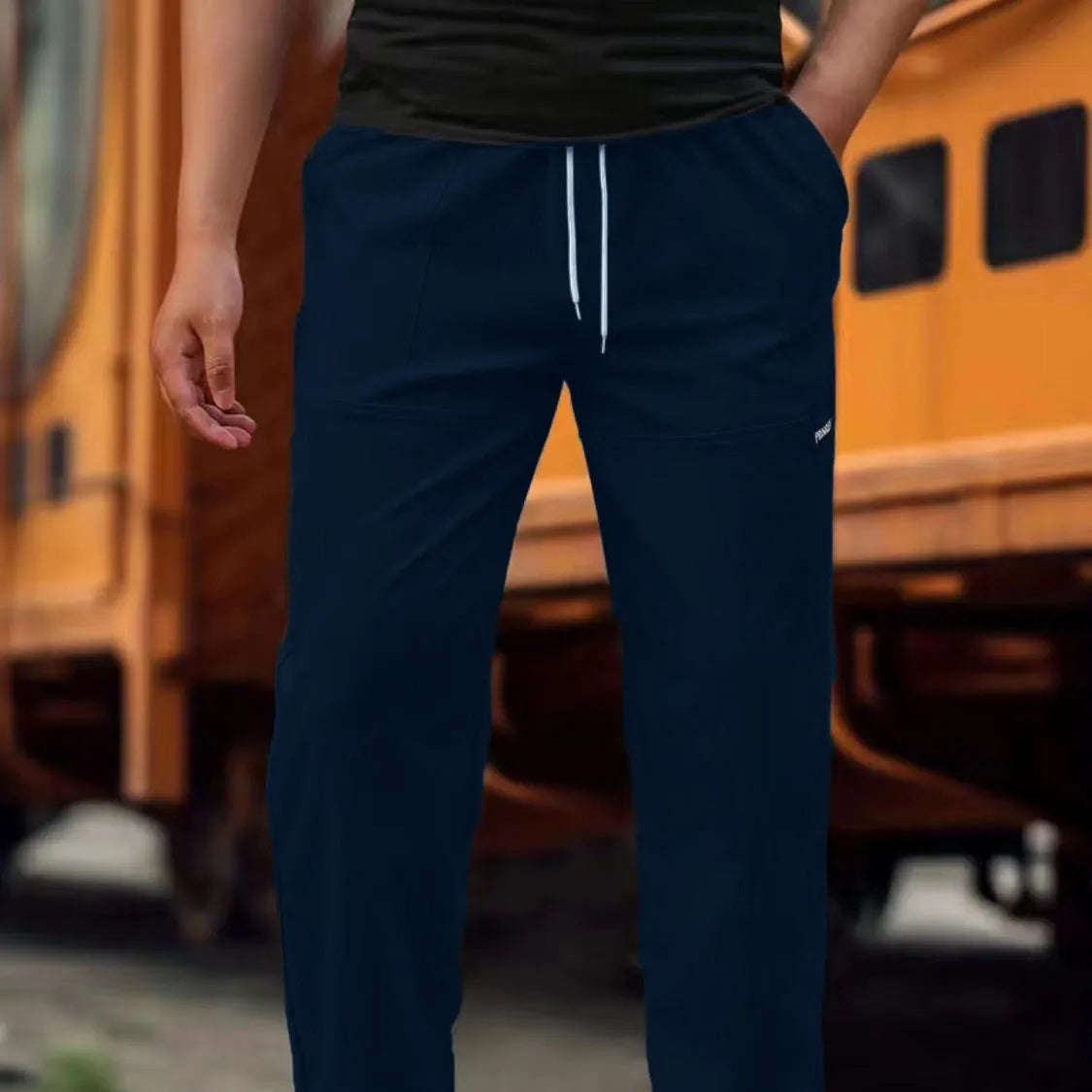 Men's polyester trousers for spring and autumn in light grey, shown flat.
