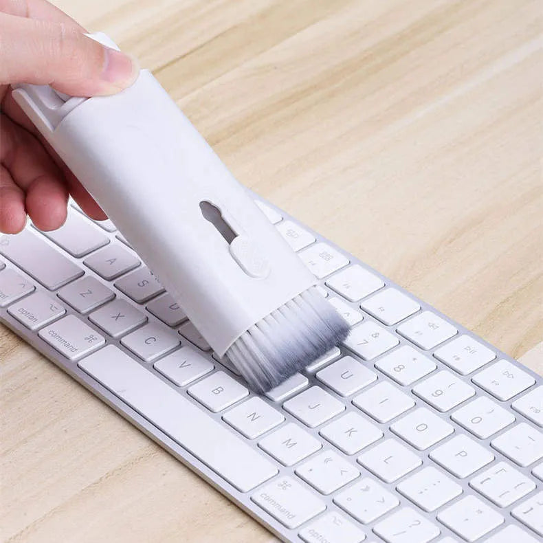 White cleaning set with pen, brush, keycap puller, and spray bottle on desk