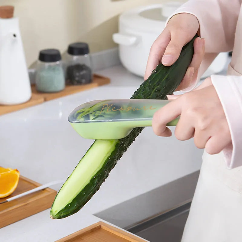 Dark green kitchen peeler with storage tube showing stainless steel blade and hangable handle