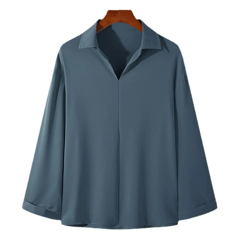 Man wearing a loose fit, solid colour, long sleeve casual shirt suitable for business.