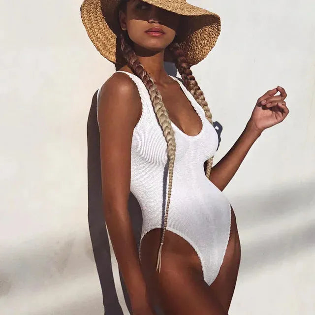 Solid colour seersucker fabric one-piece swimsuit with a backless, sleeveless design on a mannequin