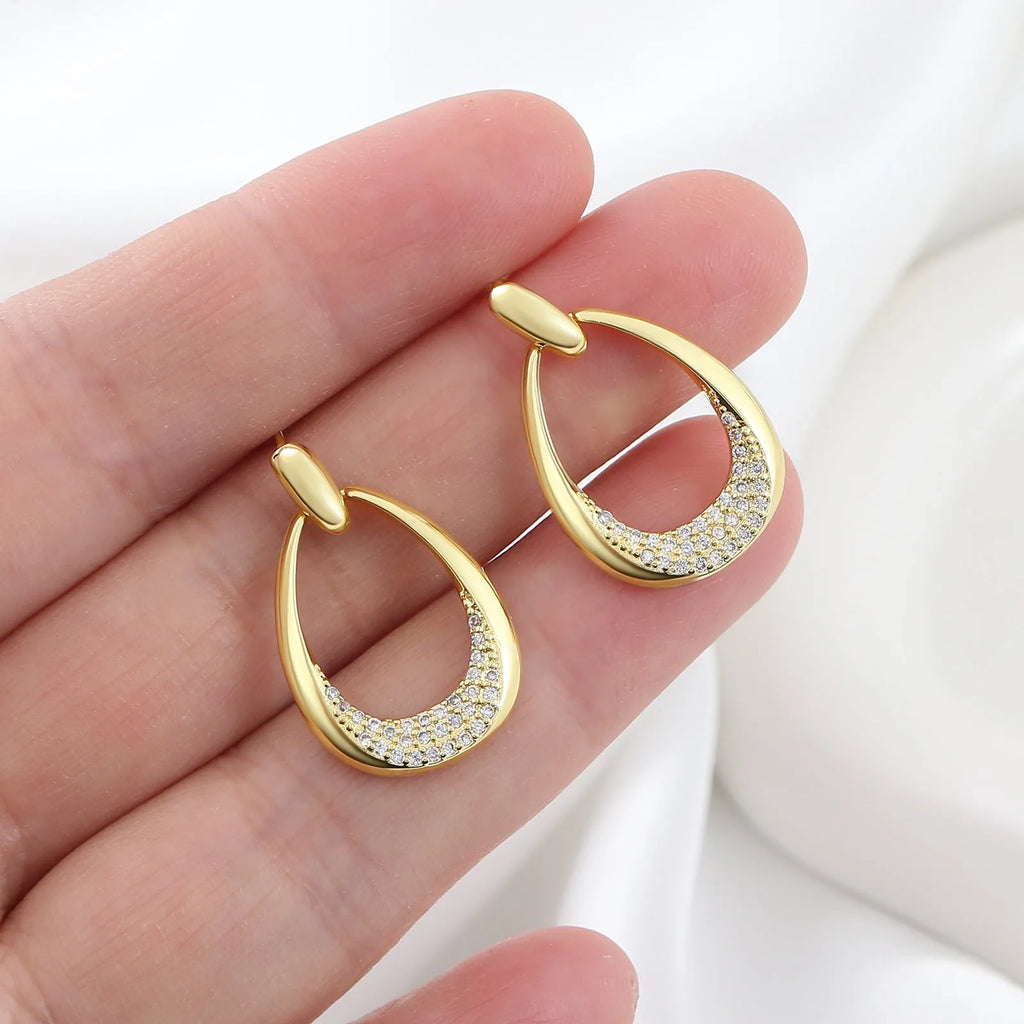 Yellow gold geometric drop earrings with oval and round ring elements on copper