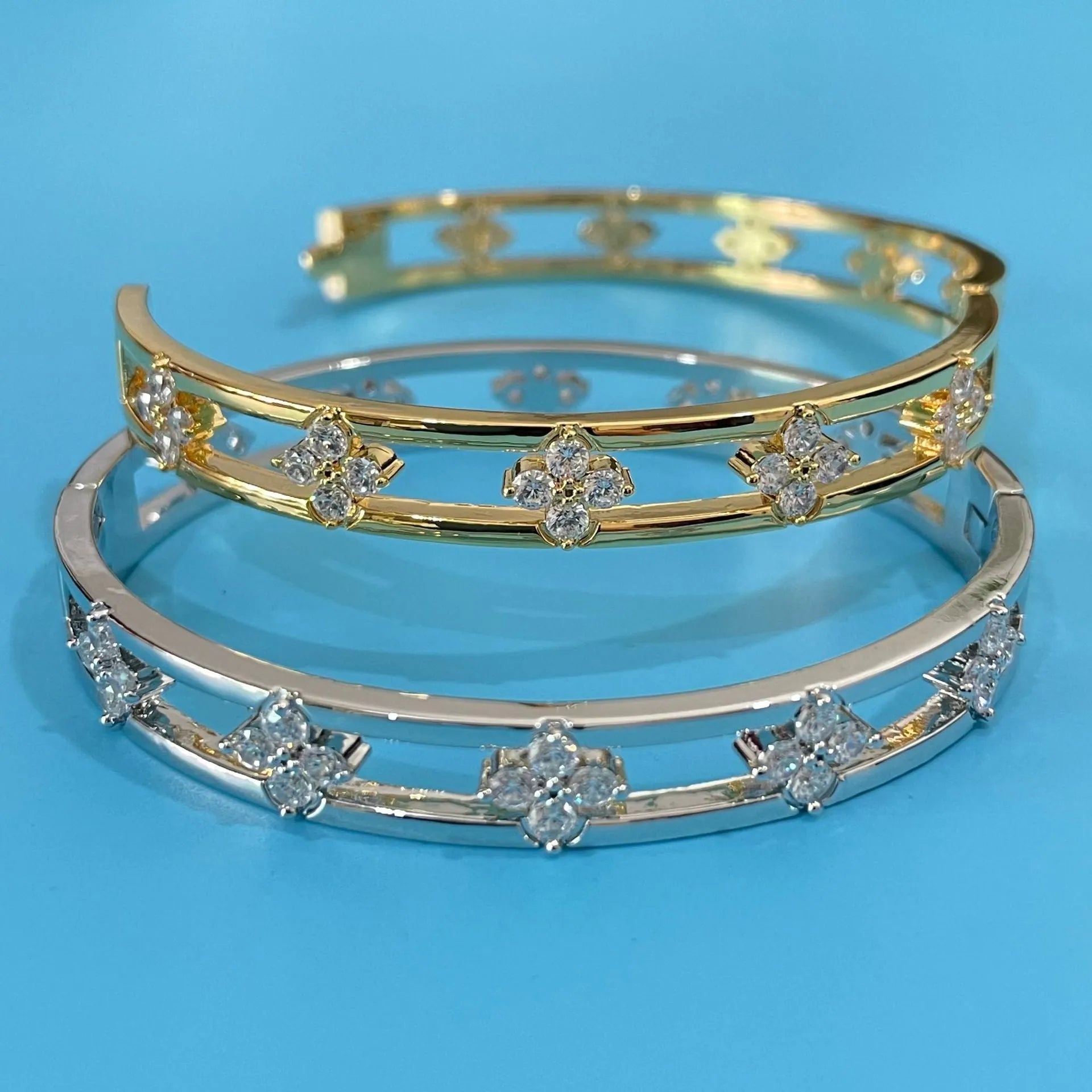 Women's hollow bracelet with four-leaf clover charm and zircon inlay detailing on copper-plated gold