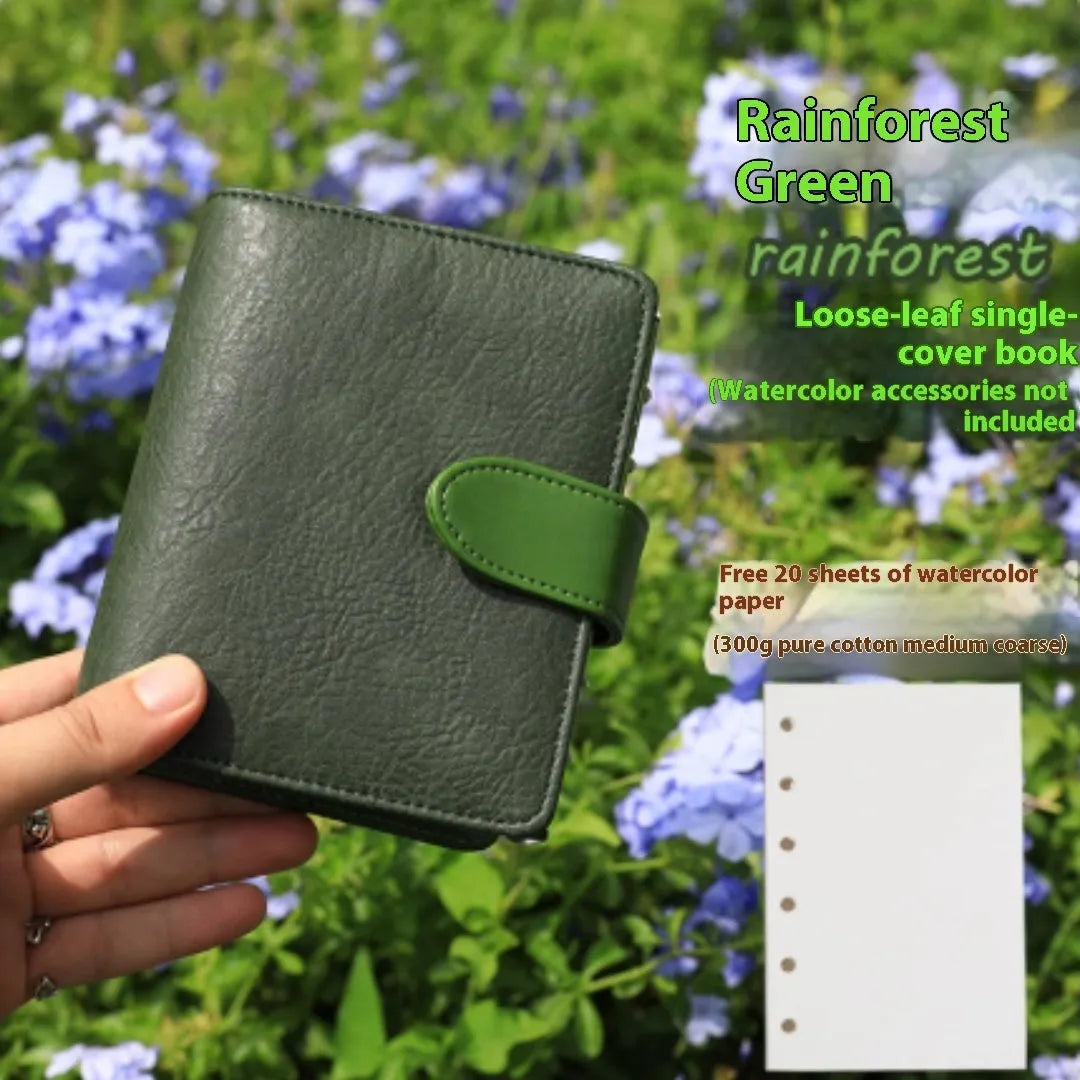 A7 format loose-leaf watercolour notebook in green, shown open on a page with a watercolour wash.