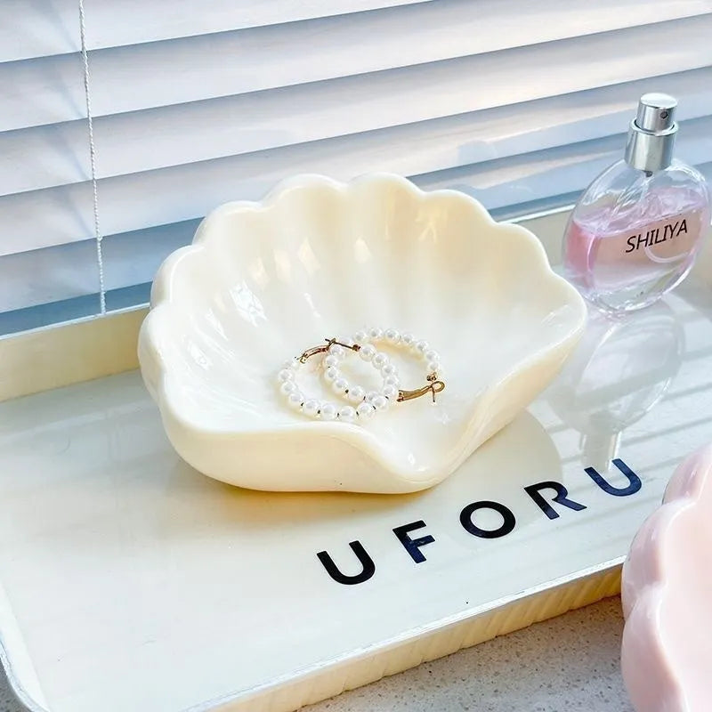 White shell-shaped plastic soap dish on a bathroom counter.