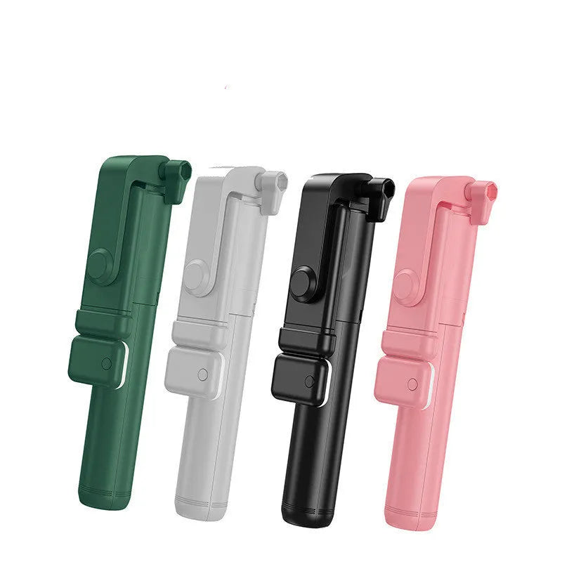 Black Bluetooth selfie stick with extended tripod legs, fill light, and a phone mounted in the 360-degree rotatable holder.