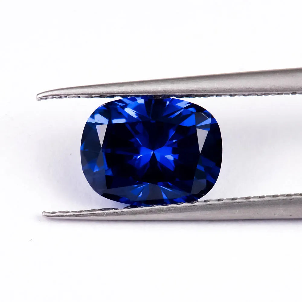 Royal blue loose cultured gemstone in heart, round, and pear shapes on a grey background.