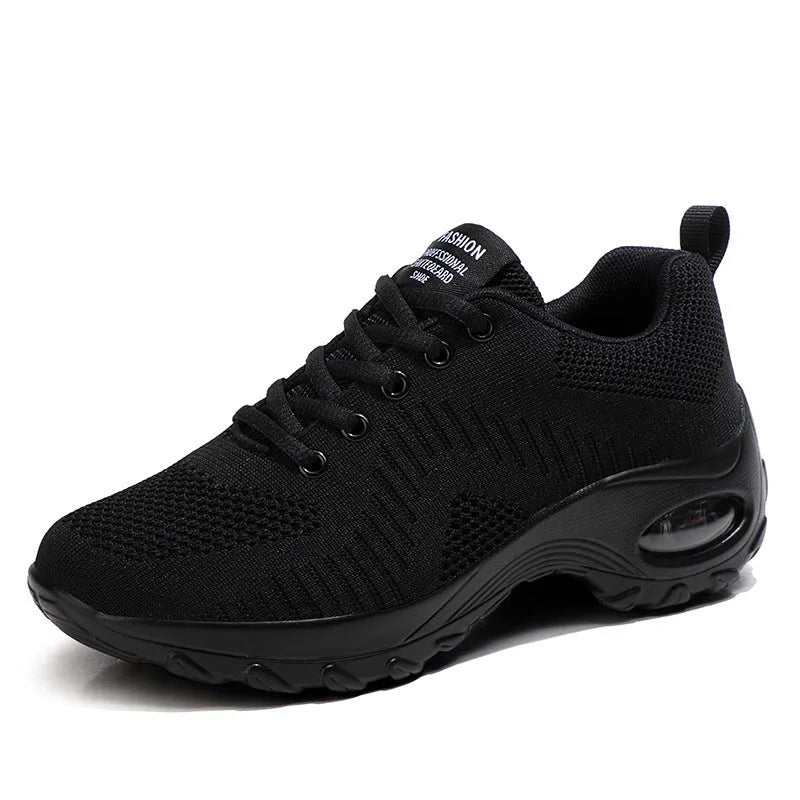 Women's black mesh sneakers with front lace-up and round toe, showing mid-heel profile
