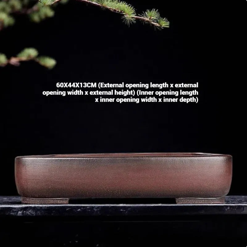 Handmade antique-style rectangular purple clay flower pot on a wooden surface.