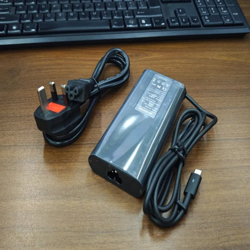 Black 65W USB-C laptop power adapter with six international travel plug cords.