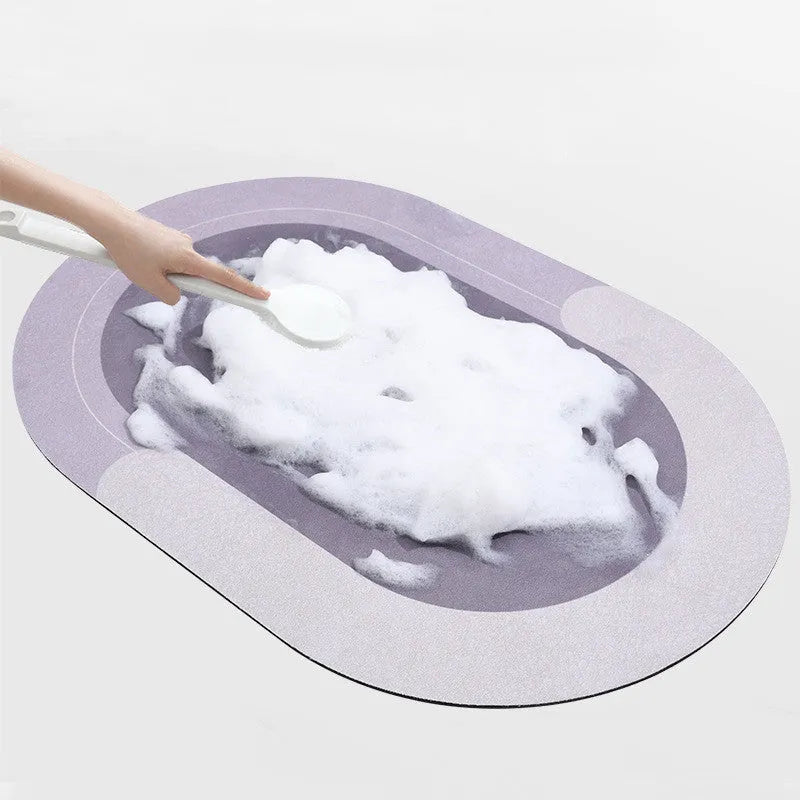 Grey oval super absorbent polyester bath mat with non-slip rubber bottom on tiled floor