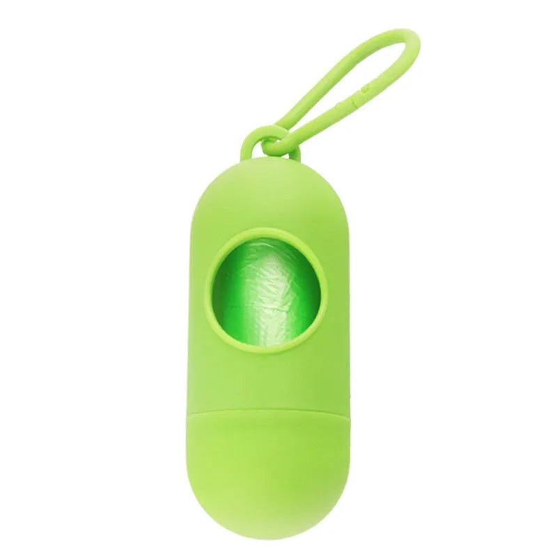 Compact black dog waste bag dispenser with a metal hook and Velcro strap, shown attached to a dog lead.