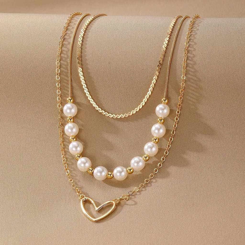 Vintage gold heart pearl necklace with adjustable chain on white background