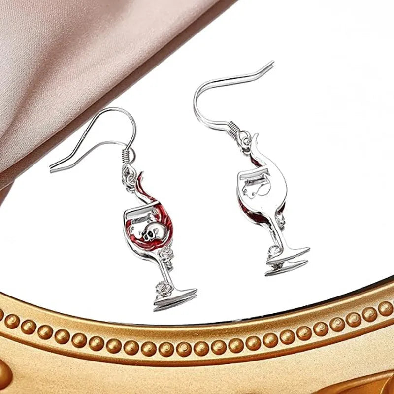 A pair of zinc alloy skull wine glass earrings with an electroplated metallic finish.
