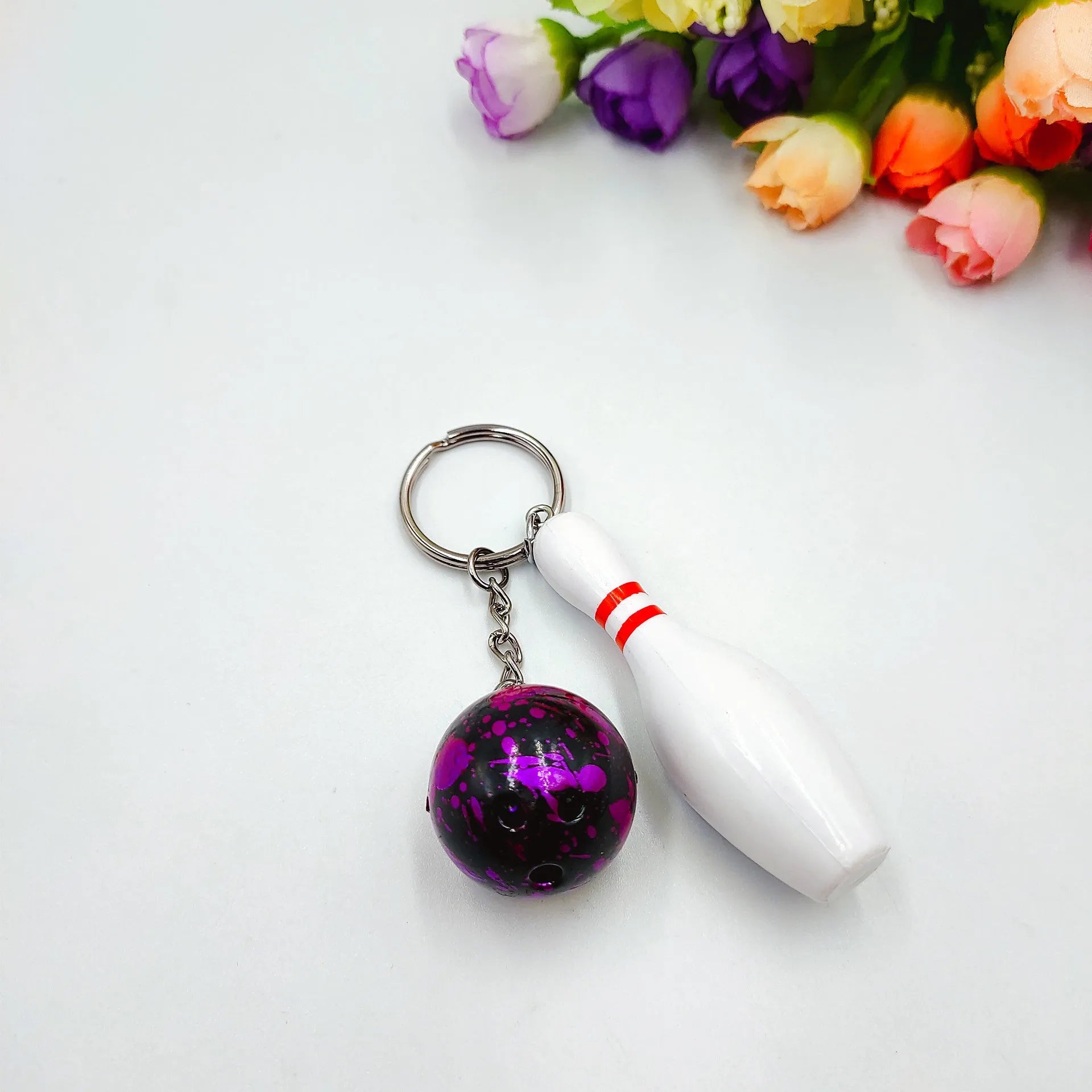 Mini bowling pin simulation keychain pendant in blue, made from PVC and metal on a key ring.