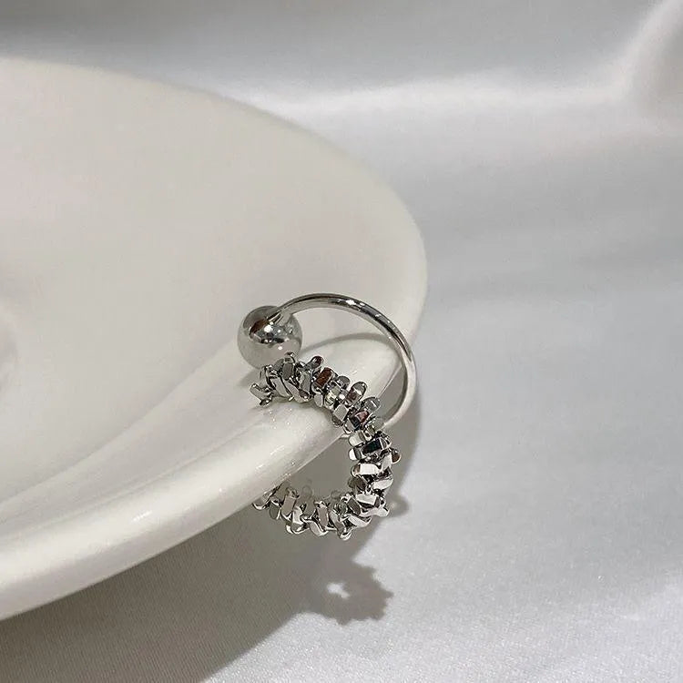 A pair of silver geometric irregular-shaped earrings with a frosted finish and clip-on fastenings.
