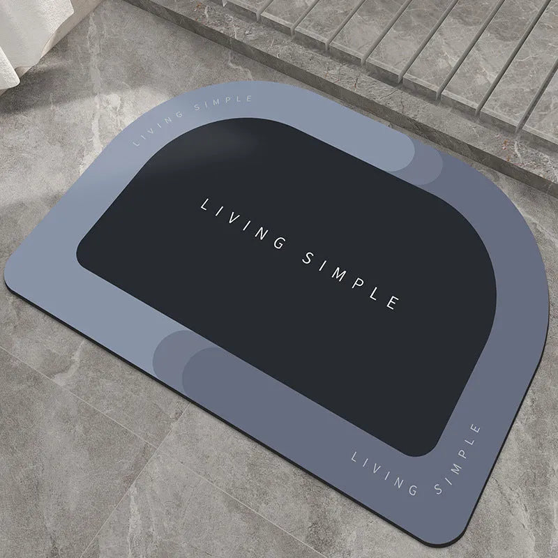 Grey oval super absorbent polyester bath mat with non-slip rubber bottom on tiled floor