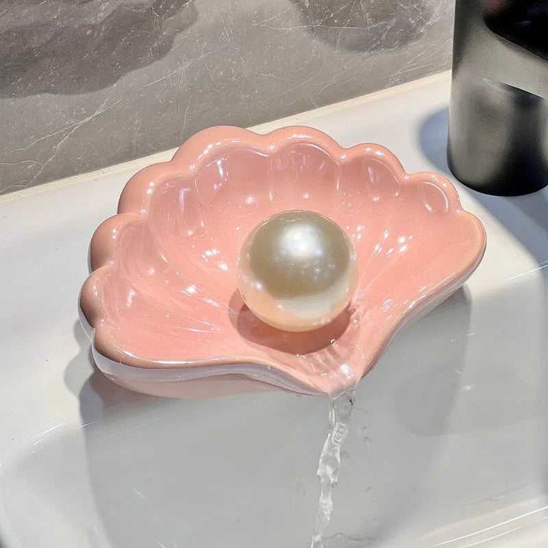 White shell-shaped plastic soap dish on a bathroom counter.
