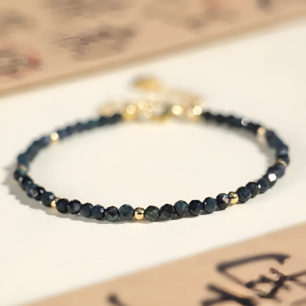 Close-up of a women's blue tourmaline beaded bracelet with 3mm beads and spacer sections.