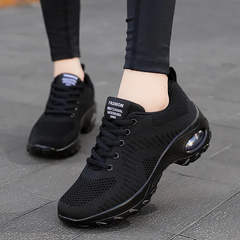 Women's black mesh sneakers with front lace-up and round toe, showing mid-heel profile