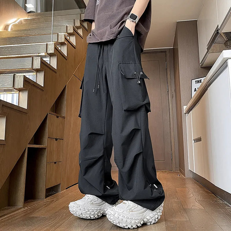 Women's plus size loose fit waterproof trousers in black, grey, or white, featuring a straight leg and elastic drawstring waist.