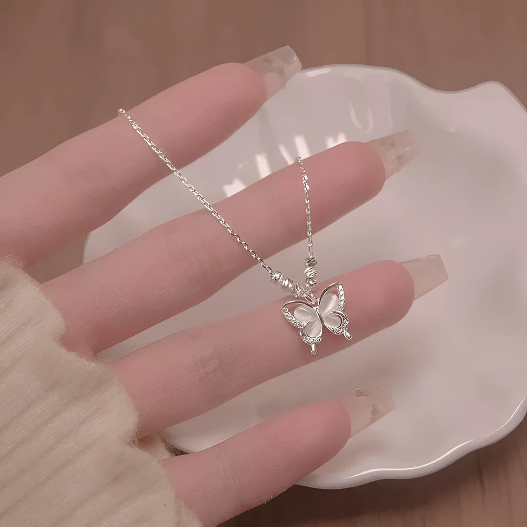 Silver butterfly necklace with opal accents on adjustable cross chain