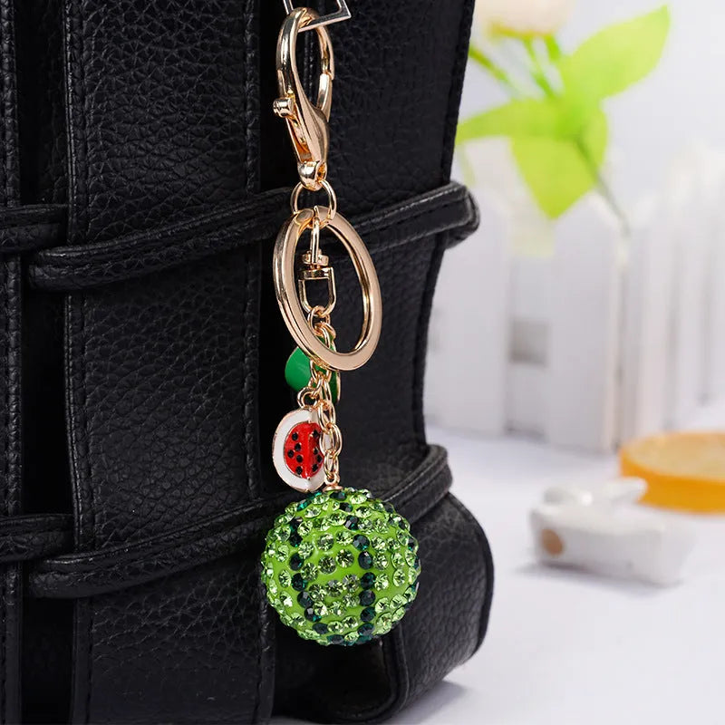 Green watermelon slice shaped zinc alloy keychain measuring 12cm long.