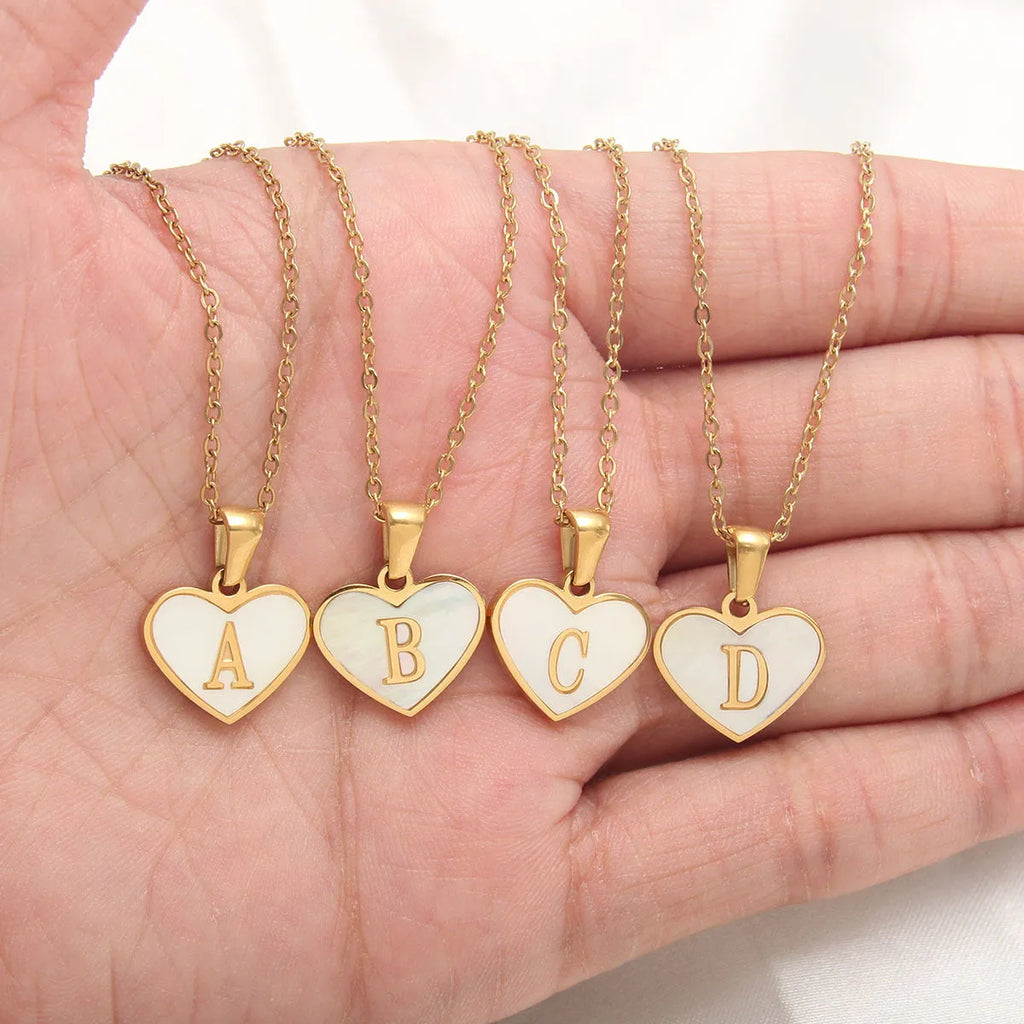 Gold heart necklace with white shell detail and personalised initial letter on adjustable chain