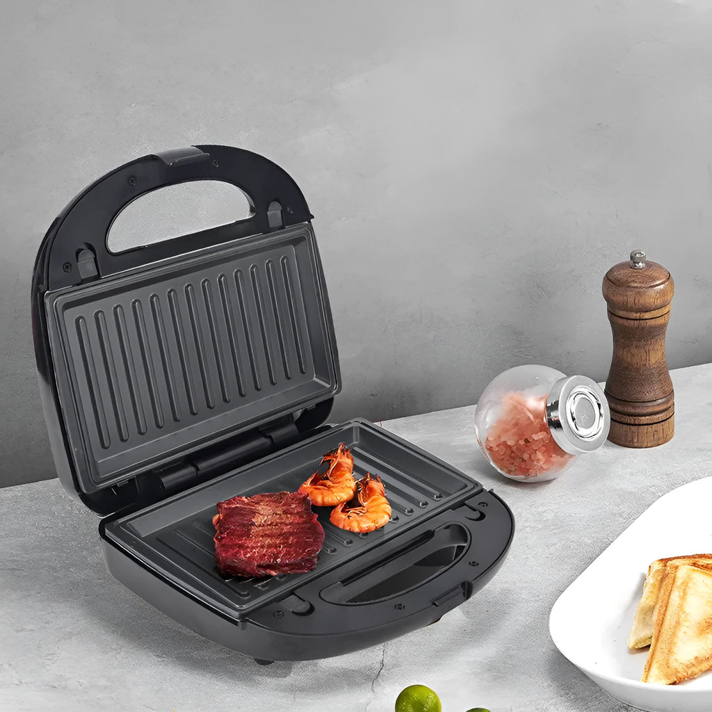 Black electric sandwich pan with double-sided heating, brushed stainless steel top, and non-stick baking surface