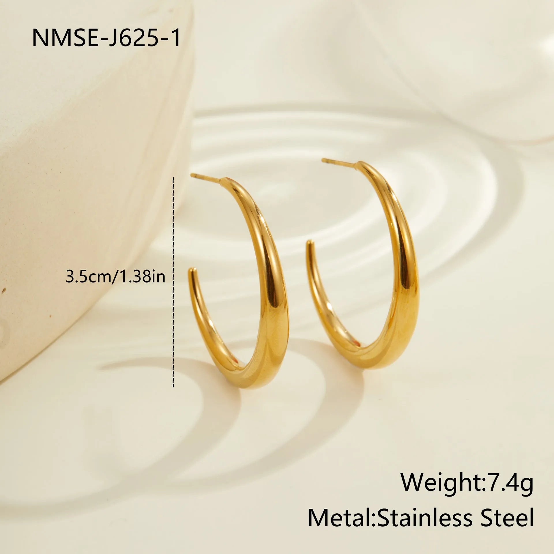 A pair of simple round titanium steel hoop earrings in a gold finish on a white background.
