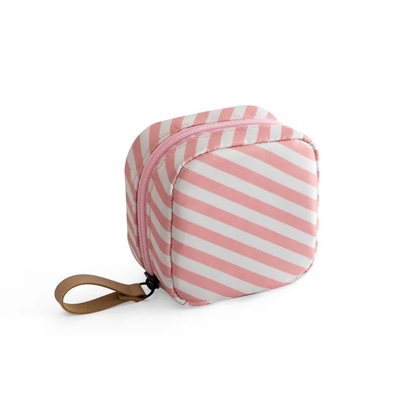 A cube-shaped cloth makeup storage bag available in blue, pink, white, and white pink colours.