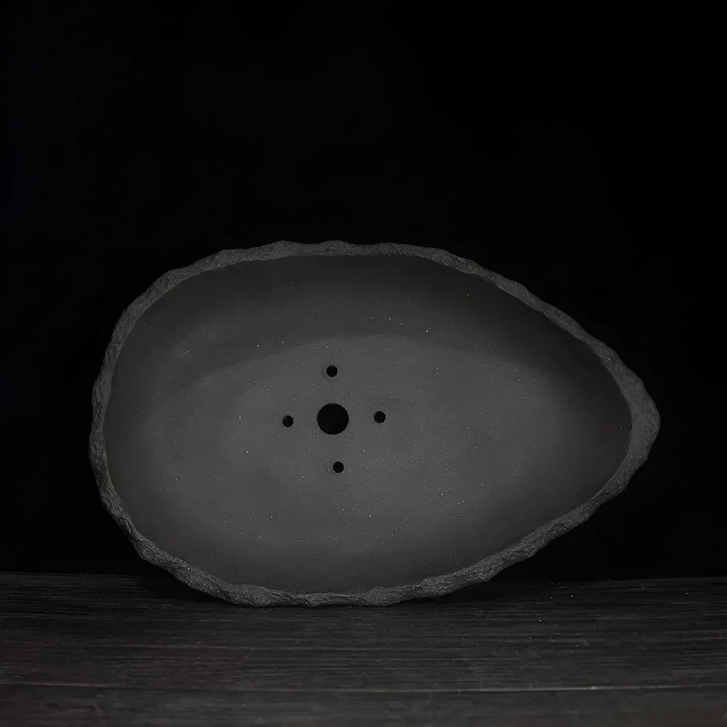 Handmade purple clay flower pot with a unique shape on a floor, showing one of five available style colours.