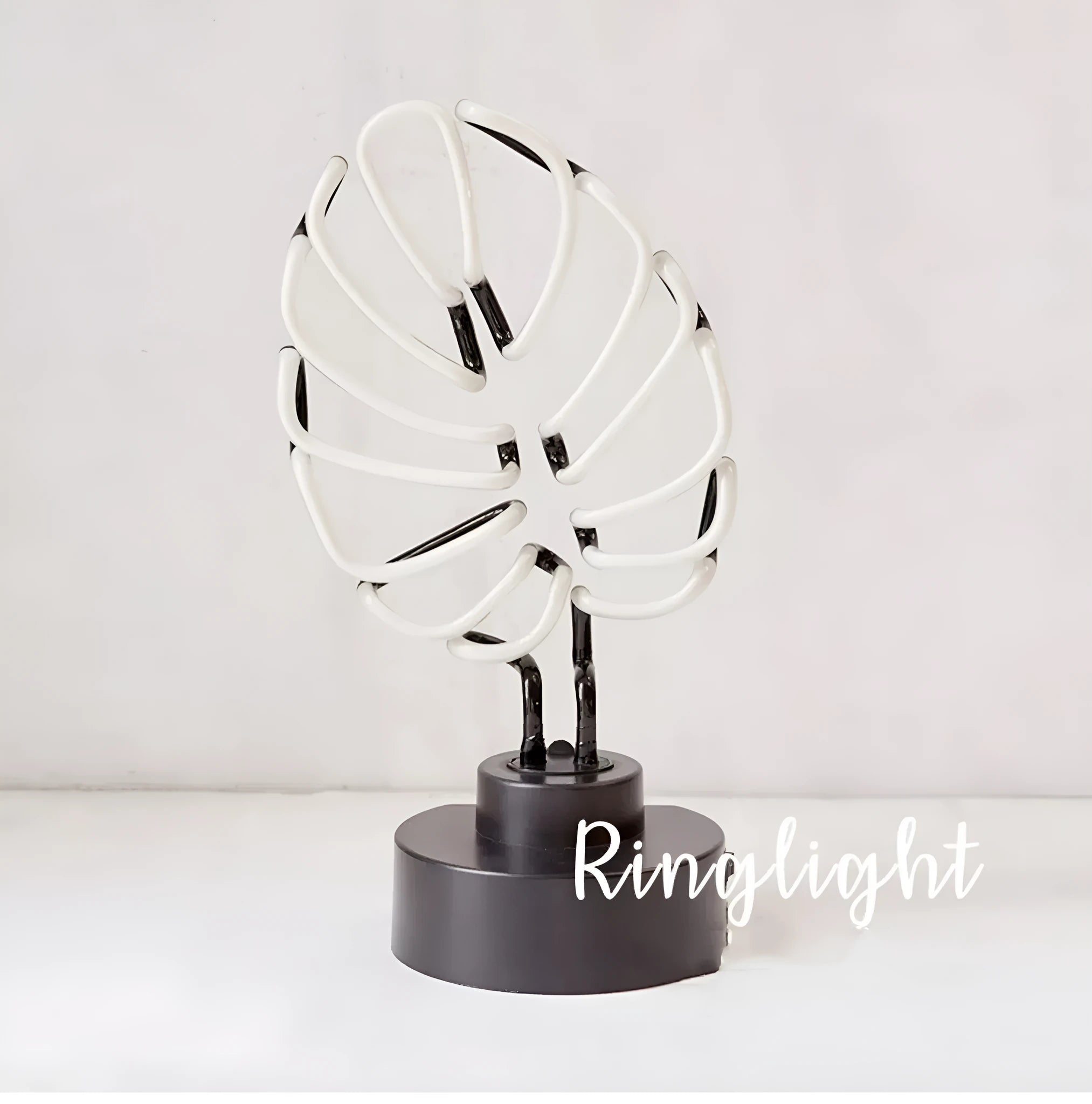 Minimalist bamboo-shaped white desk lamp with green illumination on wooden desktop