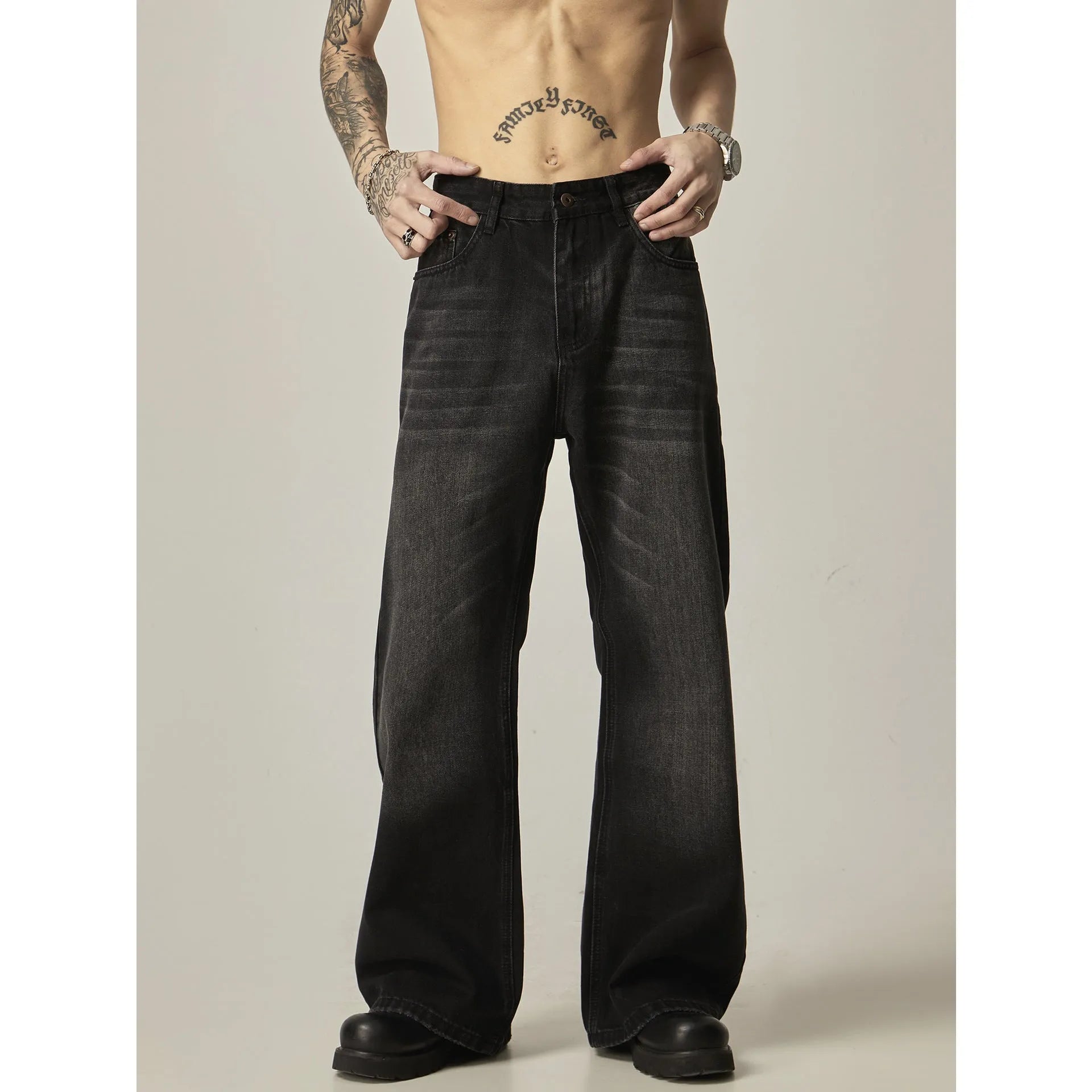 Black loose straight-leg retro jeans on a hanger, showing the front view with zipper fly.