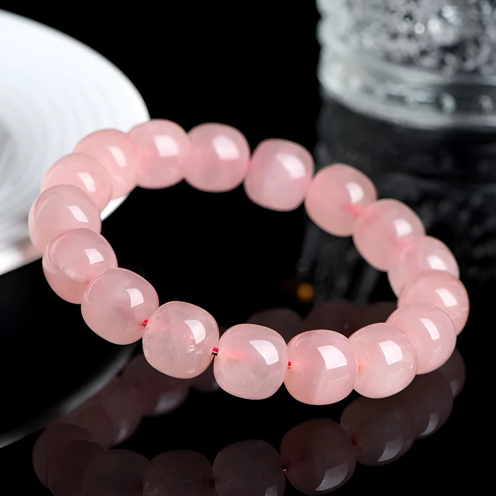 Pink crystal barrel bead stretch bracelet with 8-10mm polished beads on a wrist.