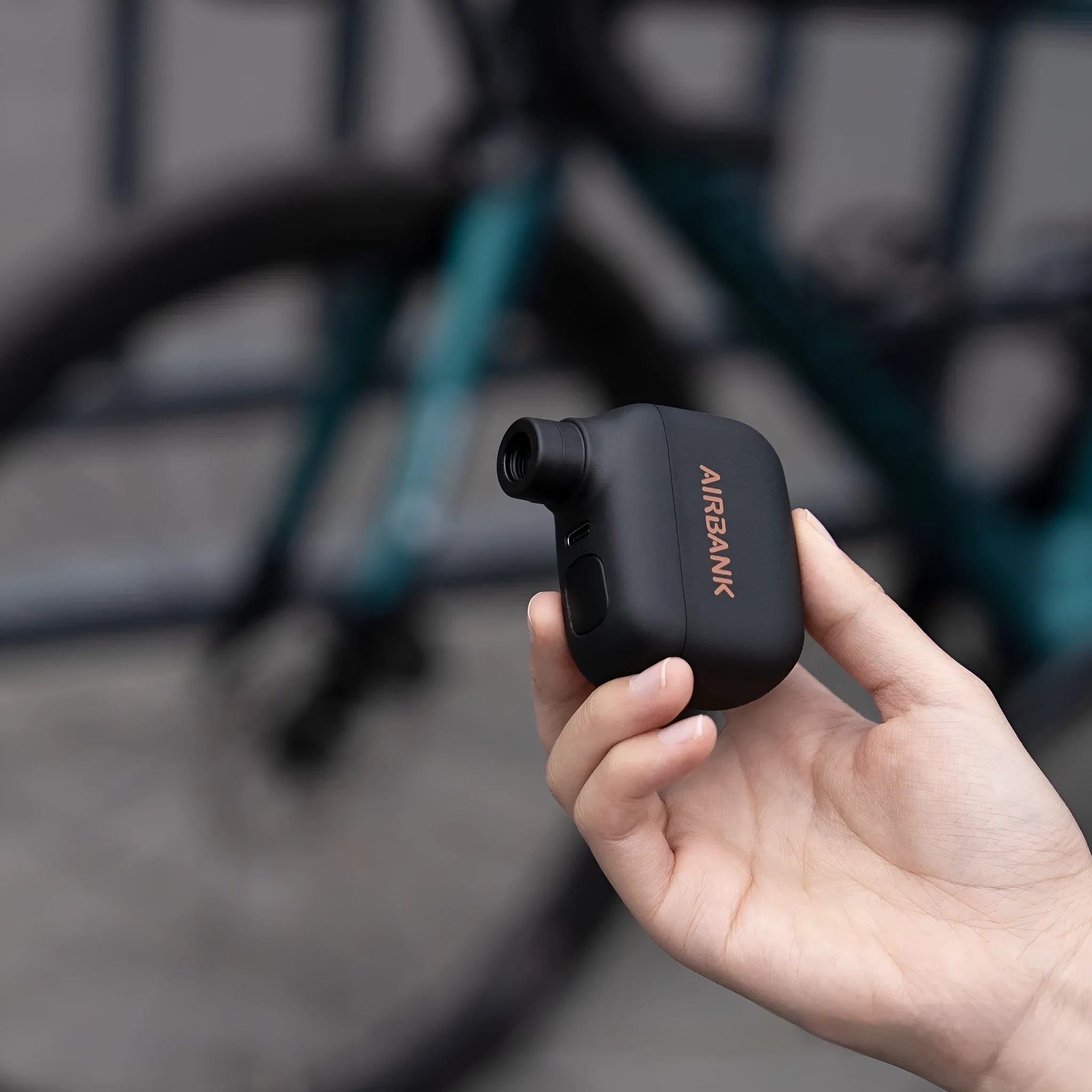 Black AS100 mini electric bike pump with USB charging cable and waterproof storage bag