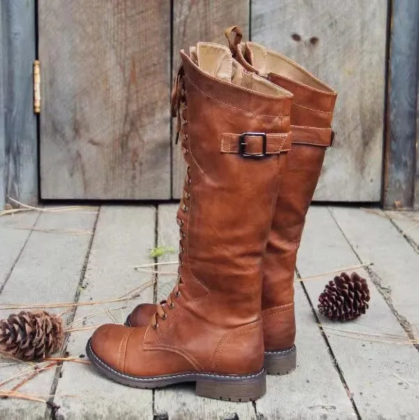 Women's black chunky heel high leg boots with a round toe on a plain background.