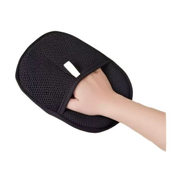 Black pet hair removal glove with silicone bristles, shown on a hand grooming a dog.