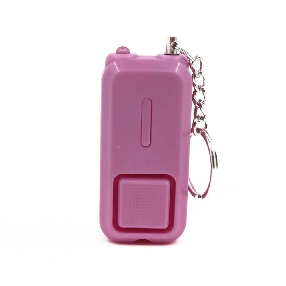 Compact pink personal safety alarm with keyring, showing dimensions next to a ruler.
