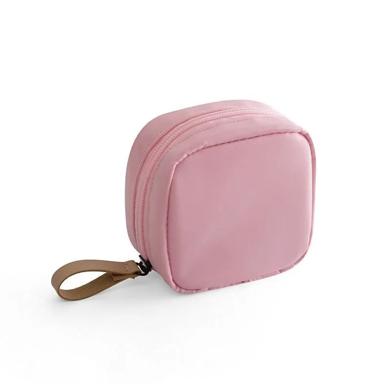 A cube-shaped cloth makeup storage bag available in blue, pink, white, and white pink colours.