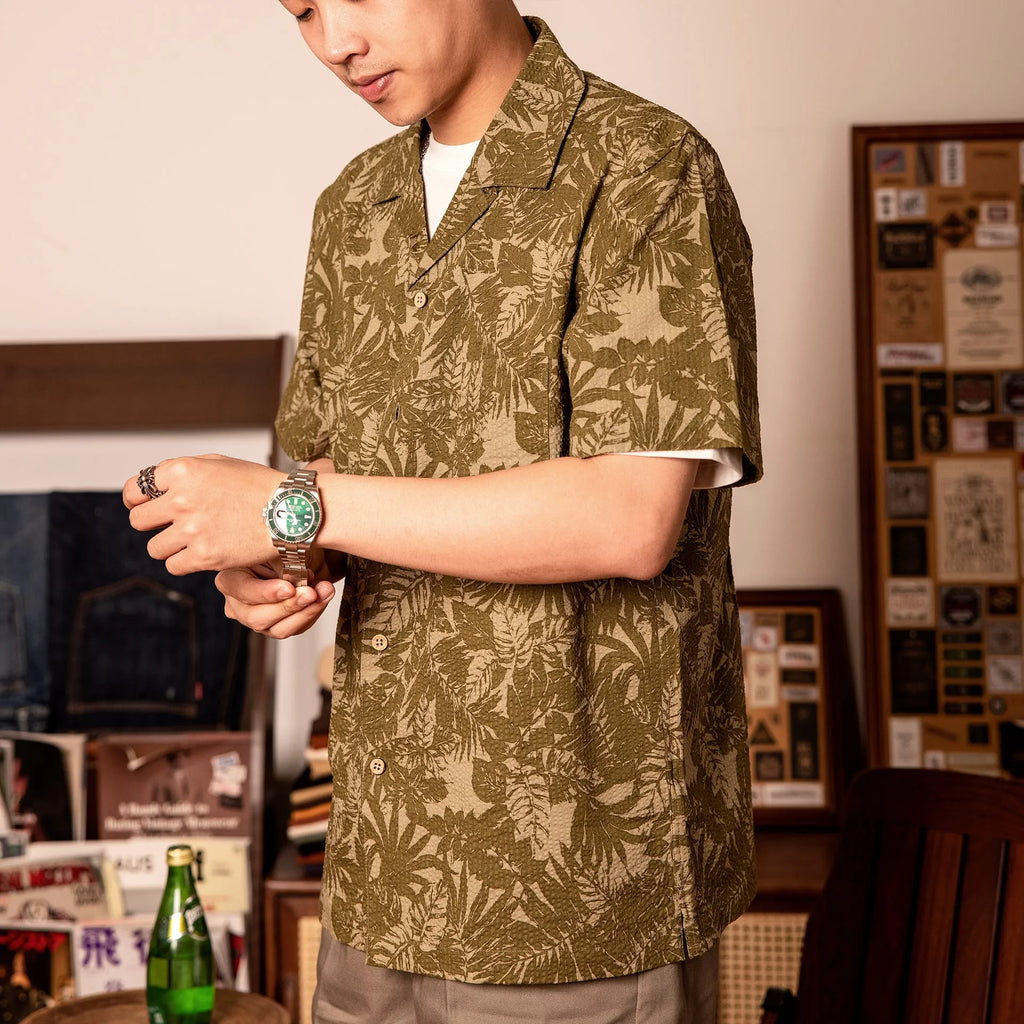 Men's green seersucker shirt with floral print and a Cuban collar, laid flat.