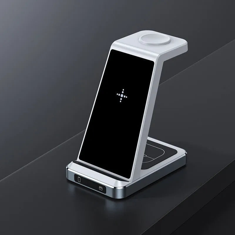 Three-in-one wireless charger in black with phone, watch, and earbuds placed on charging zones