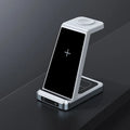 Three-in-one wireless charger in black with phone, watch, and earbuds placed on charging zones