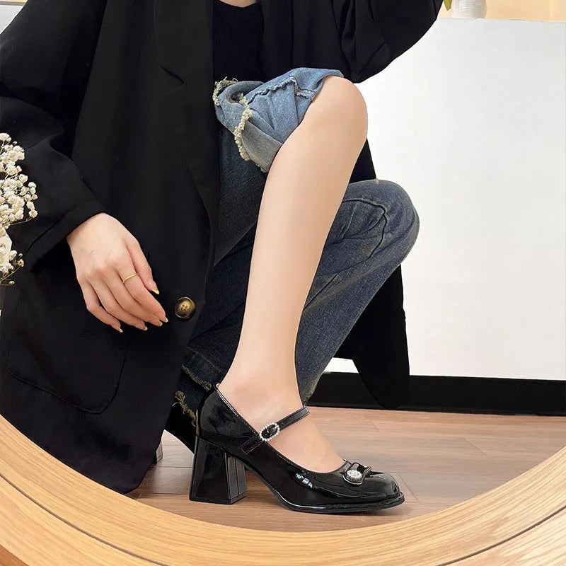 Women's black patent leather chunky heel shoes with round toe and buckle fastening, shown in a wide fit style.
