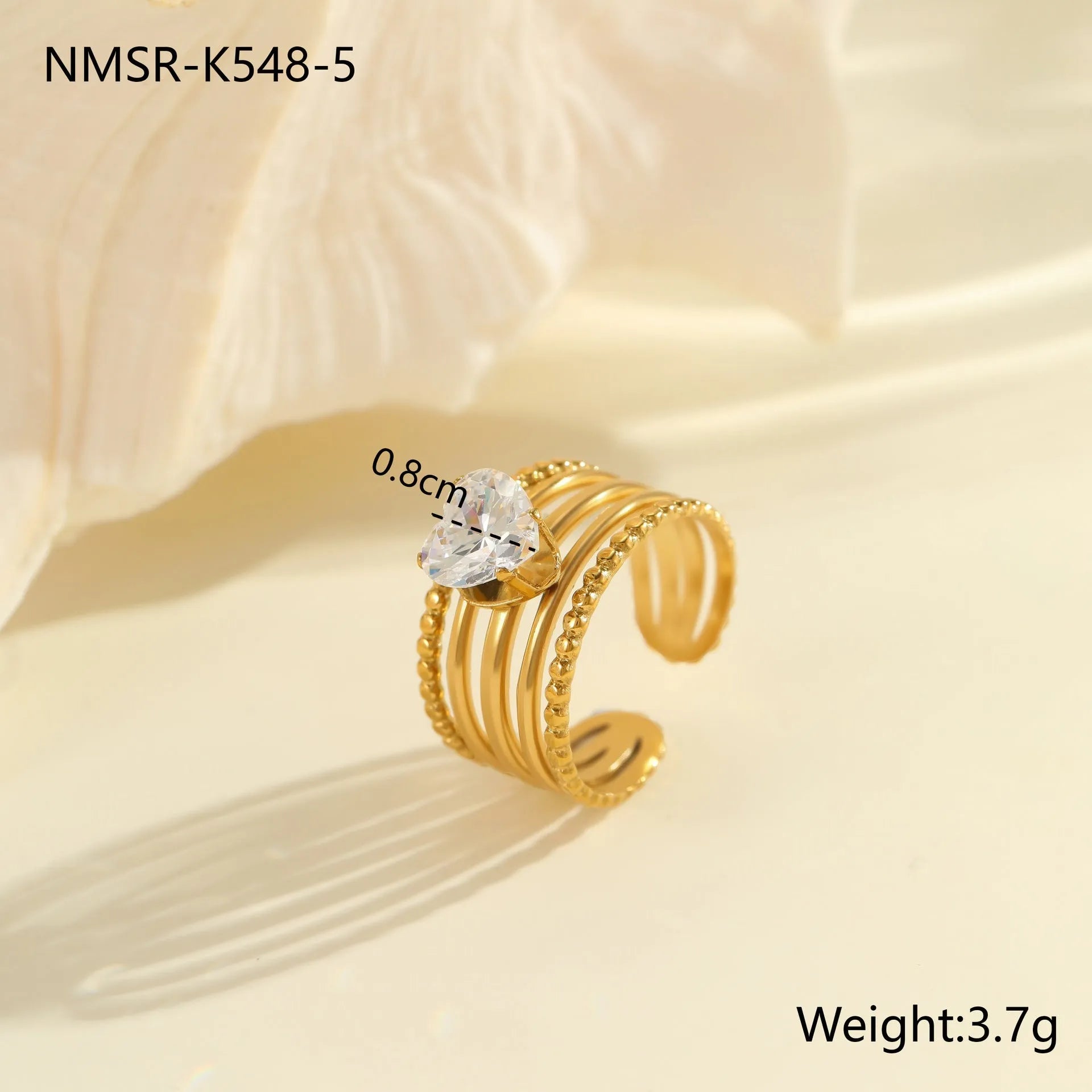 Gold-plated geometric stainless steel ring with inlaid zircon stones on a white background.