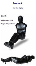 Black patent leather bondage suit with six ratchet tie down pieces for full body restraint