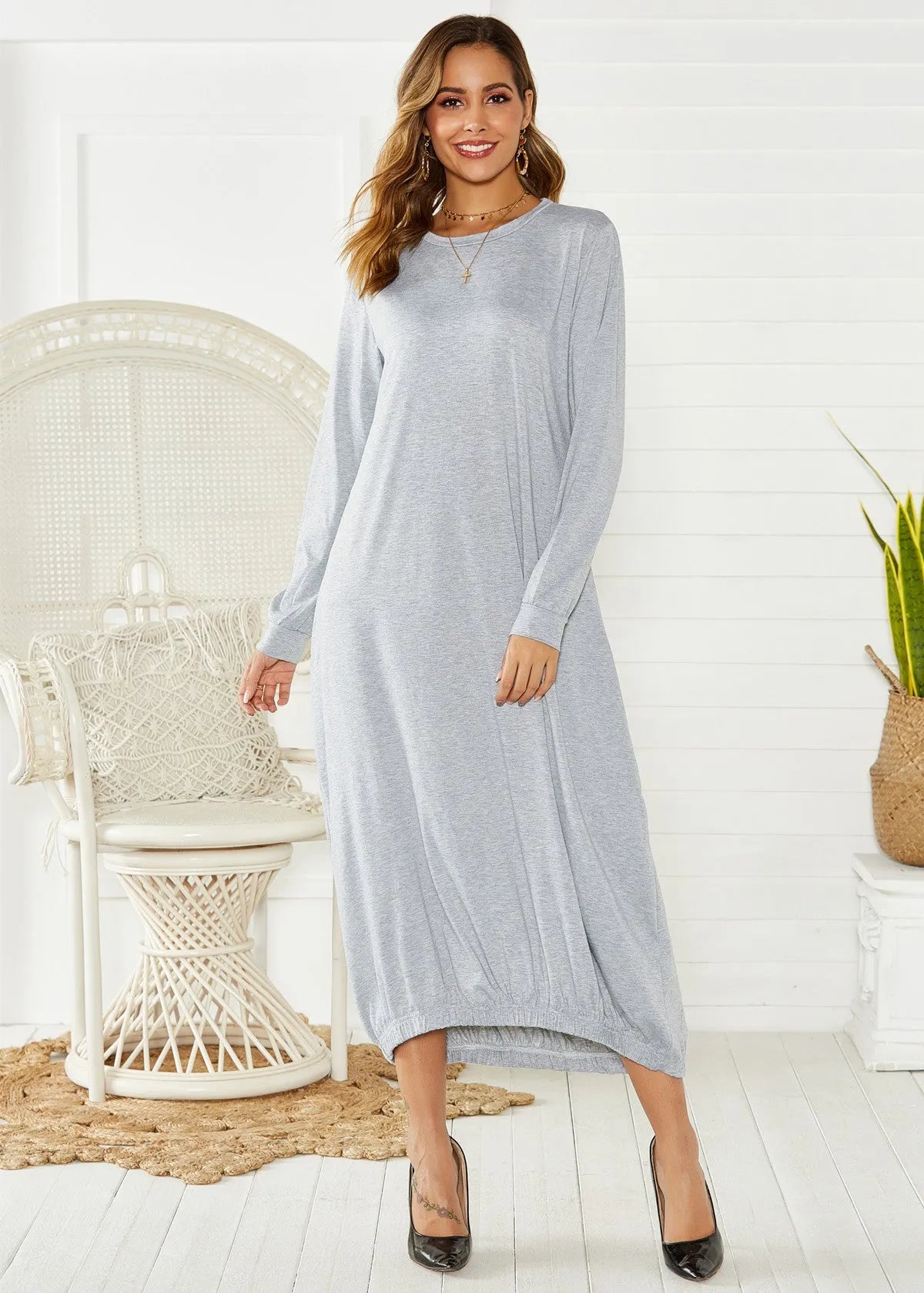 A grey loose-fitting long lantern dress with long sleeves and a crew neckline, laid flat.
