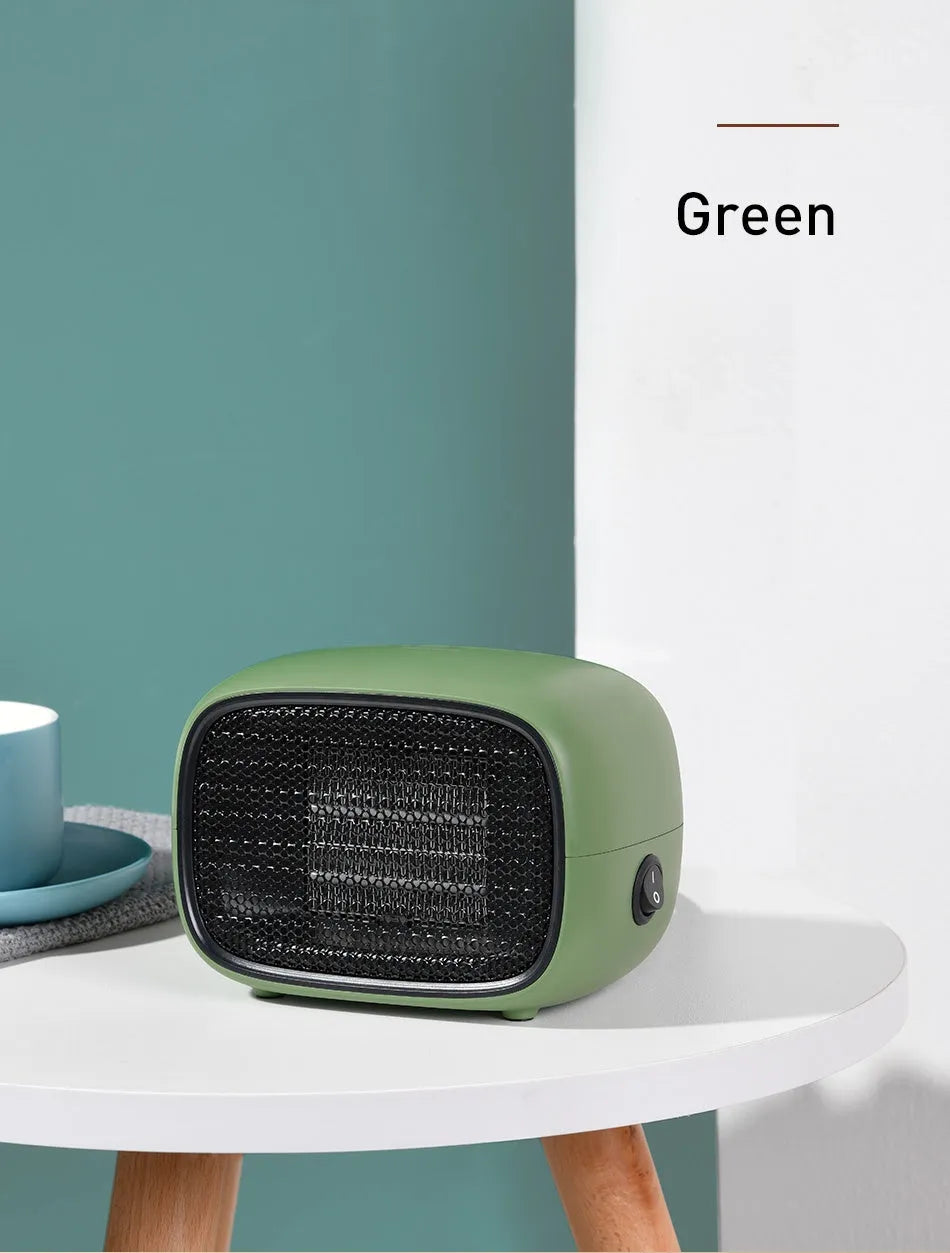 Green, white and yellow mini personal space heater on a desk showing compact size.