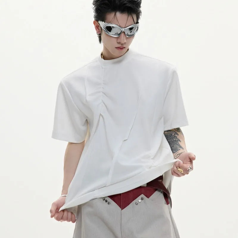 Man modelling a loose grey cotton T-shirt with a round neck and asymmetric stitching detail on the front.