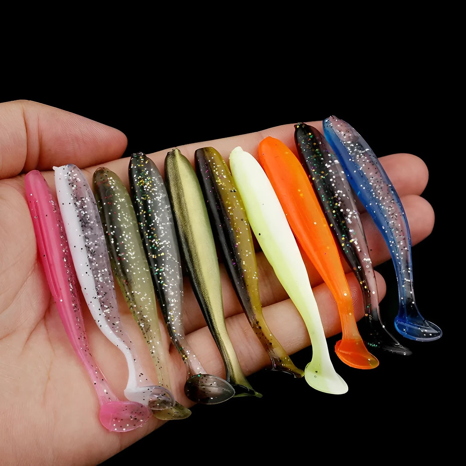 Soft plastic fishing lure in a two-tone colour scheme with a distinctive T-tail, shown alongside a ruler indicating its 7cm length.